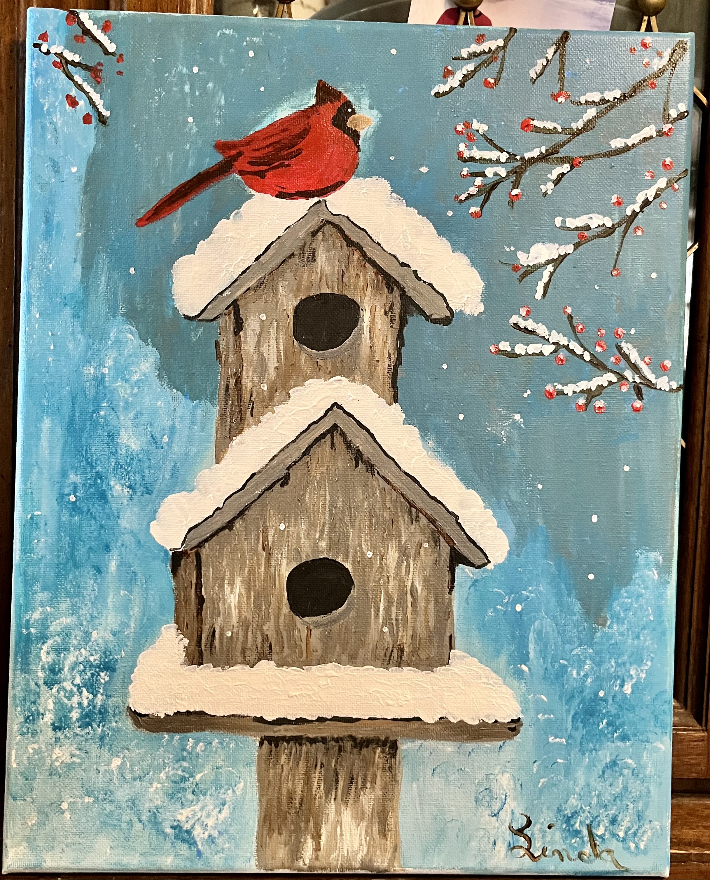 A painting of a bird atop a birdhouse
