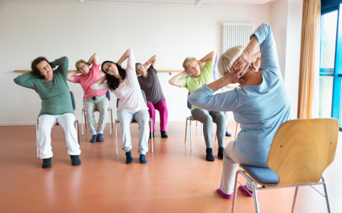 older people stretch sitting in chairs