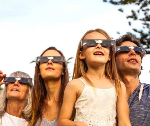 Family with eclipse glasses on.