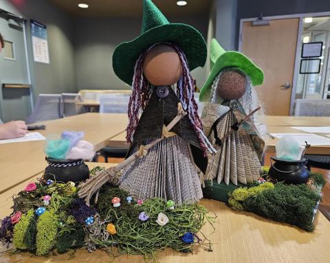 Halloween witch made out of a recycled book with a black plastic cauldron