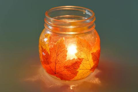 leaves on a glass jar to make a tea light luminary