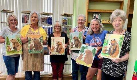 women holding paintings