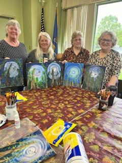 Artists holding paintings created in class.