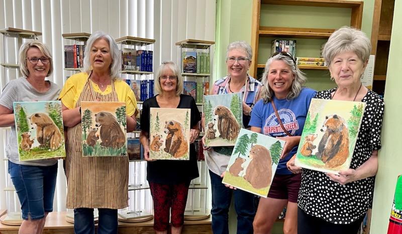 women holding paintings
